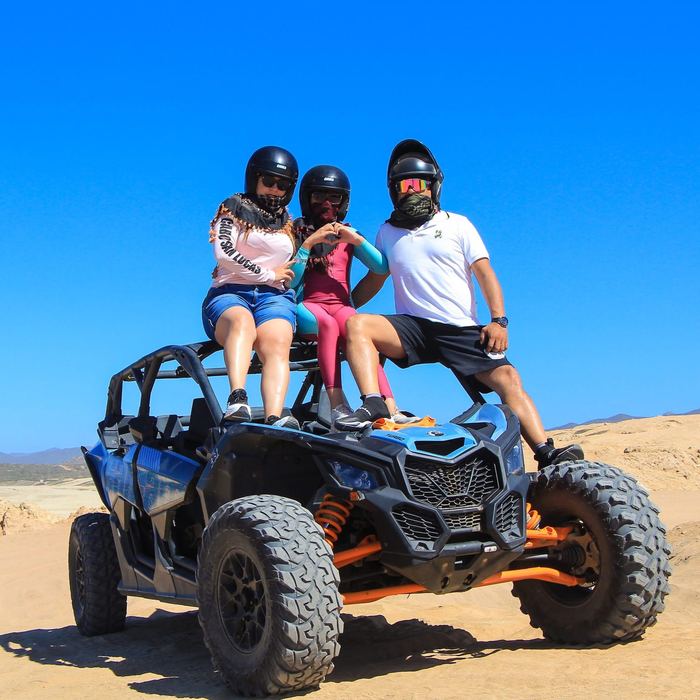Familia en un RZR en las dunas