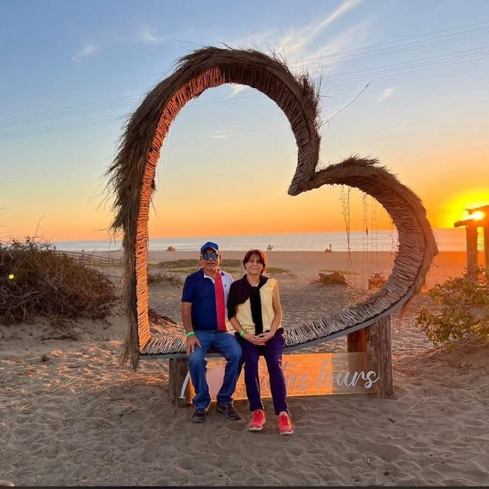 Pareja en el columpio de corazón al atardecer